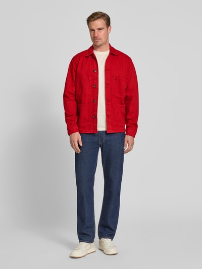 Männermodel trägt Regular Fit Hemdjacke aus reiner Baumwolle von Tommy Hilfiger in Rot, mit Brust- und Eingrifftaschen, Ganzkörperansicht von vorne.