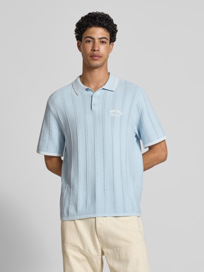 Męski model nosi Regular Fit Poloshirt in Strick-Optik model 'Menton' od Jack & Jones, bawełna, krój regular fit, jasnoniebieska, z krótkim rękawem, imitacja dzianiny, długość tyłu w rozmiarze M: 70 cm, koszulka polo; całkowity widok z przodu.