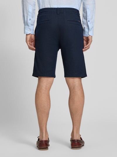 Männermodel trägt dunkelblaue Tapered Chinoshorts aus Leinen-Mix Modell 'DS_3S' von BOSS Orange, Flammgarnstruktur, Ganzkörperansicht Rückansicht.