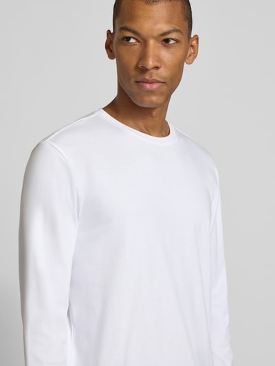 Männermodel trägt Longsleeve aus reiner Baumwolle von Christian Berg Men in Weiß, lockere Passform, Nahaufnahme Oberkörper.