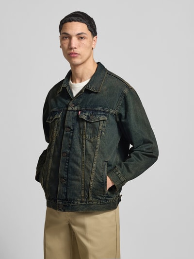 Męski model nosi Relaxed Fit Jeansjacke aus reiner Baumwolle Modell 'TRUCKER' von LEVI'S®, ciemnoniebieski denim, Ganzkörperansicht z przodu