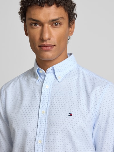 Męski model nosi Slim Fit Freizeithemd aus reiner Baumwolle von Tommy Hilfiger, efekt: wzór na całej powierzchni, popelina, kołnierzyk typu button down, listwa guzikowa na całej długości, długi rękaw, mankiet zapinany na 1 guzik, widoczne logo, jasnoniebieskie odcienie, gładka tekstura, koszula casualowa, widok: z przodu, zbliżenie na górną część ciała.
