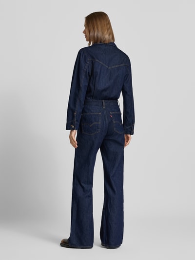 Frauenmodel trägt Regular Fit Jumpsuit aus reiner Baumwolle von Levi's® 300 in Dunkelblau mit sichtbaren Nähten, Ganzkörperansicht Rückansicht.