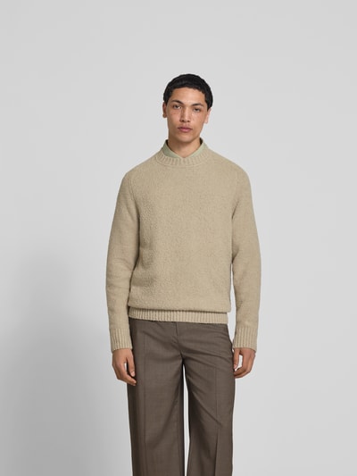 Männermodel trägt Relaxed Fit Pullover in Strick-Optik von Forét aus Bouclé-Optik im elastischen Baumwoll-Mix, Beige, Rundhalsausschnitt, Rückenlänge 66 cm bei Größe M, Ganzkörperansicht von vorne.