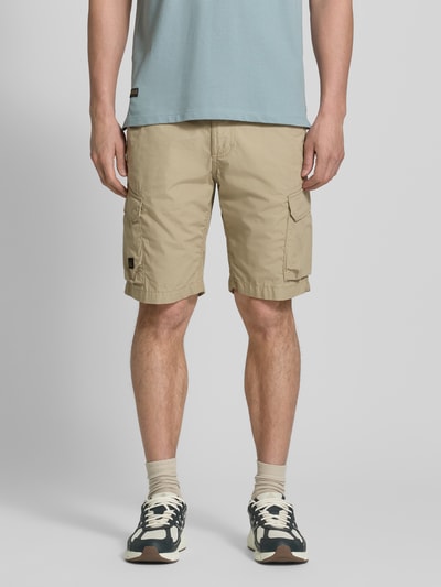Männermodel draagt Bermudas met cargozakken van camel active in beige, puur katoen, regular fit, steekzakken, labeldetail, bandwijdte maat 32: 44 cm, binnenbeenlengte maat 32: 26 cm, geheel lichaamsbeeld van voren.