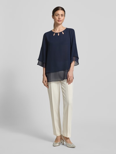 Frauenmodel trägt Regular Fit Blusenshirt aus fließendem Stoff von Vera Mont in Dunkelblau mit Stufen-Look und 3/4-Arm, Ganzkörperansicht von vorne.