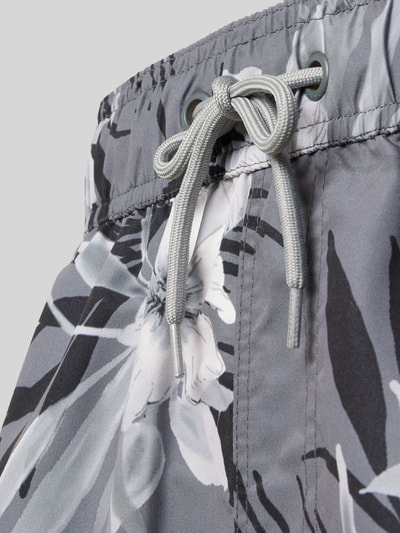 Männermodel trägt Badehose im Allover-Look Modell 'REINOLD' von Blend in Grautönen mit elastischem Bund und Tunnelzug, Nahaufnahme Oberkörper.