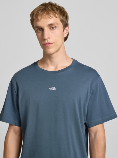 Männermodel trägt T-Shirt mit Logo-Stitching von The North Face in Blau, reine Baumwolle, gerader Schnitt, Nahaufnahme Oberkörper.
