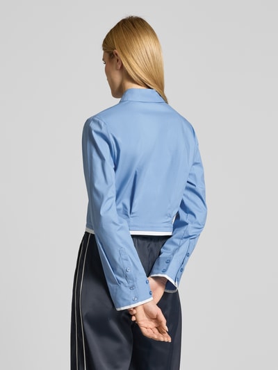 Frauenmodel trägt Cropped Hemdbluse mit gelegten Falten Modell 'Zopy' von Gestuz aus elastischem Baumwoll-Mix in Hellblau, Langärmeliges Design mit Hemdblusenkragen und durchgängiger Knopfleiste, Rückenlänge bei Größe 36: 47 cm, Ärmellänge 63 cm; Ganzkörperansicht Rückansicht.