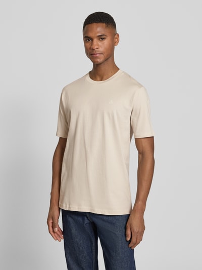 Männermodel trägt Regular Fit T-Shirt aus reiner Baumwolle von Marc O'Polo in Beige mit Logo-Print, Rundhals, kurzarm, Ganzkörperansicht von vorne.