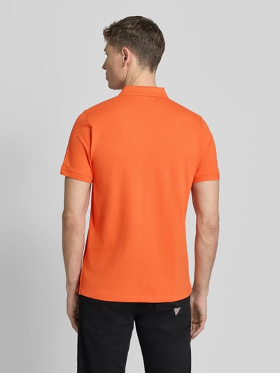 Männermodel trägt Regular Fit Poloshirt in unifarbenem Design von camel active, mieszanka bawełny i elastanu, krój regular fit, listwa guzikowa, logo, długość tyłu w rozmiarze M 70 cm, jednokolorowy pomarańczowy, gładka tekstura, Ganzkörperansicht Rückansicht.