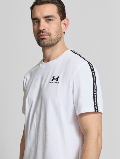 Męski model nosi Regular Fit T-Shirt mit Logo-Stitching Modell 'Icon' od Under Armour, biały bawełniany miks, okrągły dekolt, widok z przodu, zbliżenie na górną część ciała.