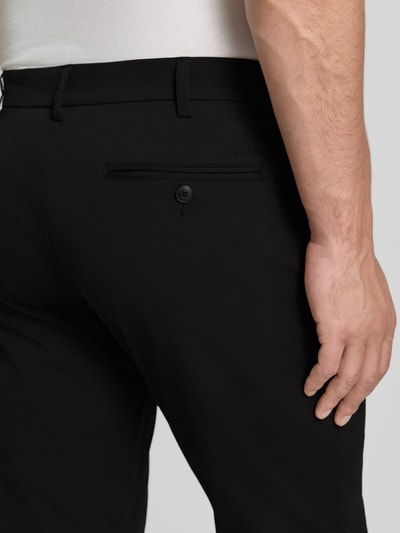 Männermodel trägt Slim Fit Hose mit Gesäßtaschen von MCNEAL in Schwarz, Knopf-Reißverschluss, Eingrifftaschen, Detailaufnahme Rückansicht.
