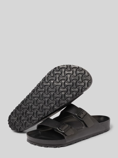 Produktfoto, Slides mit Label-Detail Modell 'ARIZONA EVA' von Birkenstock in Schwarz mit abgerundeter Form, Dornschließe, strukturierter Sohle, 4 cm Absatzhöhe bei Größe 45