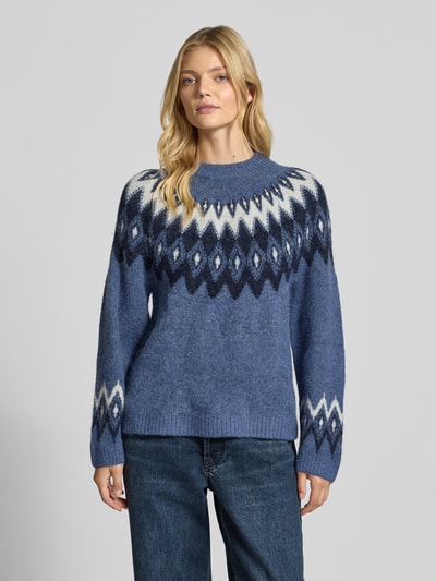 Vrouwenmodel draagt Relaxed Fit Pullover met wol-aandeel model 'Jacquard' van Gina Tricot, stricklook, ronde hals, blauwe tinten, elastisch materiaal, voorkant bovenlichaam close-up.