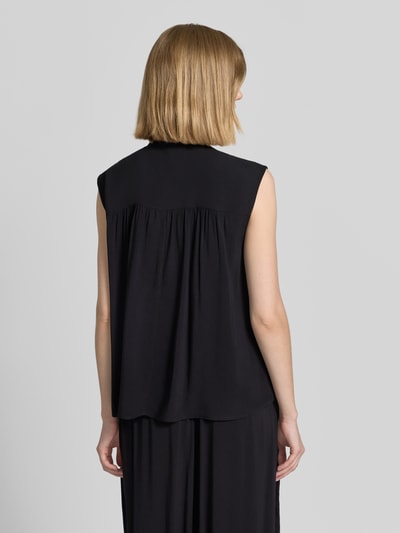 Frauenmodel trägt Blusentop mit Rüschenkragen Modell 'RADIA' von Soyaconcept aus Reine Viskose in Schwarz, Straight Fit, Rückenlänge 62 cm, Ganzkörperansicht Rückansicht.