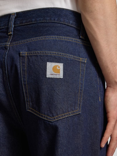 Mężczyznęmodel nosi Jeansy z wpuszczanymi kieszeniami Model 'Landon Pant Robertson' od Carhartt Work In Progress, bawełna, krój relaxed fit, szerokość w rozmiarze 32: 44 cm, długość wewnętrzna nogawki w rozmiarze 32: 78 cm, ciemnoniebieski denim, detal na tylnej kieszeni, zbliżenie tył.