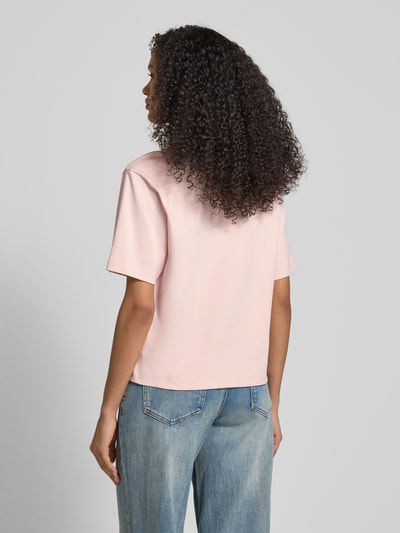Modelka kobieta ma na sobie T-Shirt in halbärmligem Design od JAKE*S STUDIO WOMAN, czysta bawełna, luźny krój, jasnoróżowy kolor, półrękaw, okrągły dekolt, długość tyłu w rozmiarze S 57 cm, widok całej sylwetki z tyłu.