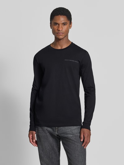 Męski model nosi czarny t-shirt Regular Fit T-Shirt aus reiner Baumwolle Modell 'solid' von Tom Tailor Denim, gładka tkanina, Ganzkörperansicht von vorne