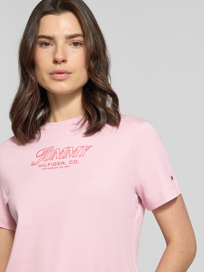Frauenmodel trägt Slim Fit T-Shirt aus reiner Baumwolle von Tommy Hilfiger, Optik: Unifarben, Label-Print, Jersey, Nahaufnahme Oberkörper.