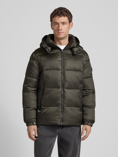 Mężczyznamodel nosi Kurtka pikowana z kieszeniami zapinanymi na zamek błyskawiczny od JOOP! Collection, prosty krój, kaptur, kolor khaki, długość tyłu 75 cm, szerokość ramion 49 cm, szerokość klatki piersiowej 45 cm, długość rękawów 69 cm, gładka tekstura, całkowity widok z przodu.