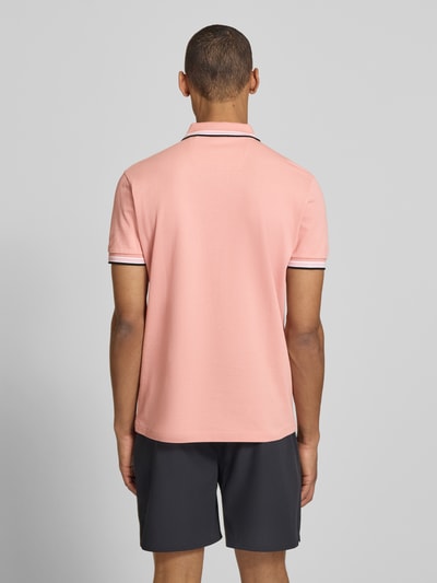 Männermodel trägt Regular Fit Poloshirt aus reiner Baumwolle Modell 'PADDY' von BOSS Green in Rosa, unifarben, Piqué, Ganzkörperansicht Rückansicht.