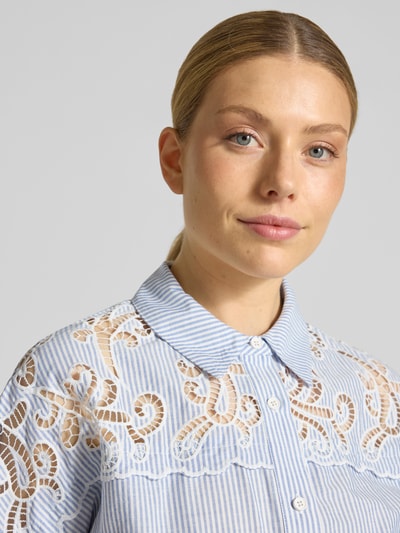 Frauenmodel trägt Regular Fit Hemdbluse mit Häkelspitze Modell 'LOlITA' von SUNCOO PARIS aus reiner Baumwolle mit Kentkragen und 1/2-Arm, Nahaufnahme Oberkörper.