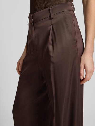 Frauenmodel trägt Wide Leg Hose aus Viskose von Jake*s Collection in Braun, fließender Stoff mit Drapierungen, Detailaufnahme Oberkörper.
