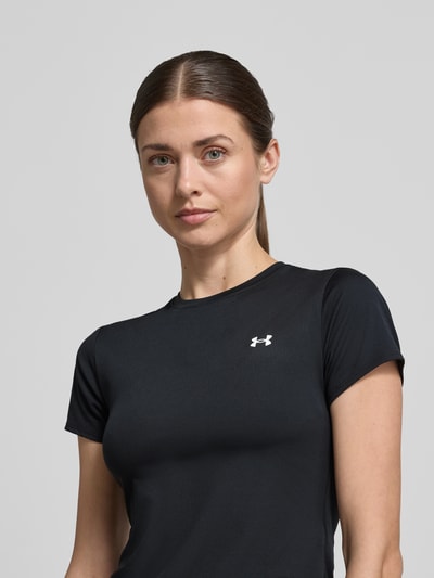 Vrouwenmodel draagt T-shirt met ronde hals en logoprint van Under Armour, zwart, slim fit materiaalmix met stretch, ruglengte maat S 49 cm, close-up bovenlichaam vooraanzicht
