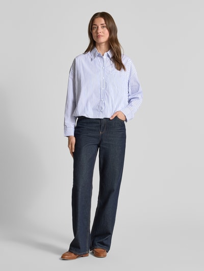 Vrouwenmodel draagt Bluse mit überschnittenen Schultern van Rich & Royal in blauw-witte strepen, puur katoen, regular fit, overhemdkraag, knoopsluiting, borstzak, ruglengte bij maat 36: 51 cm, mouwlengte bij maat 36: 47 cm, ganzkörperansicht van voren.