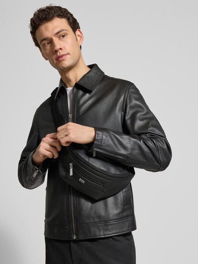 Männermodel trägt Bauchtasche mit Label-Applikation Modell 'LEWIS' von BOSS in schwarzer Lederoptik, Kunstleder, Ganzkörperansicht von vorne