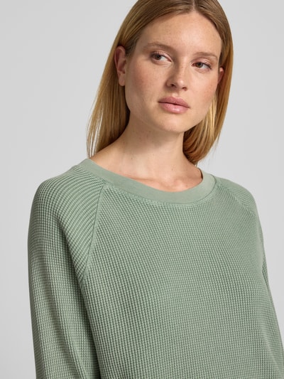 Vrouwenmodel draagt sweatshirt met structuurpatroon Model 'USCOW' van American Vintage, puur katoen, relaxed fit, ronde hals, detailopname bovenlichaam.