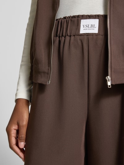 Frauenmodel trägt Wide Leg Hose aus Viskose-Mix Modell 'TOSCA' von VILLA SOPHIE, Optik: Unifarben, elastischer Bund, seitliche Eingrifftaschen, Nahaufnahme Oberkörper.