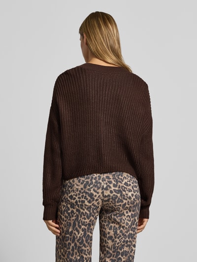 Vrouwenmodel draagt boxy fit gebreid jack met v-hals model 'CAROL' van ONLY in donkerbruin, dames, grof gebreide textuur, volledige lichaamsweergave achterkant.