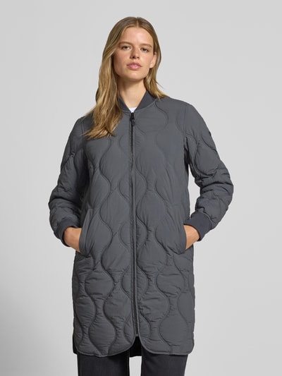 Frauenmodel trägt Steppjacke mit Stehkragen und Eingrifftaschen von Superdry in Dunkelgrau, regelmäßige Passform, sichtbare Steppnähte, Reißverschluss, seidig glatte Struktur, Ganzkörperansicht von vorne. Rückenlänge 91 cm, Schulterbreite 38 cm, Brustweite 50 cm, Ärmellänge 63 cm.