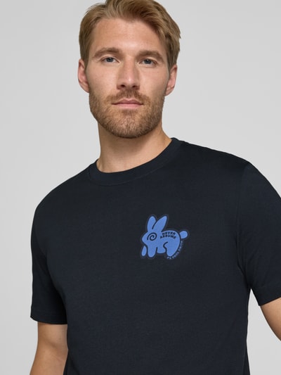 Männermodel trägt Regular Fit T-Shirt aus reiner Baumwolle von Paul Smith, dunkles Blau, Rundhalsausschnitt, Statement-Print, Nahaufnahme Oberkörper.