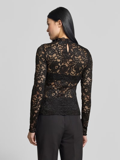 Frauenmodel trägt Slim Fit Longsleeve aus floraler Spitze Modell 'Lacey' von YAS, schwarze semitransparente Spitze, Rückenansicht, Ganzkörperansicht Rückansicht. Elastischer Material-Mix mit Stehkragen, Rückenlänge 57 cm bei Größe S, Nahaufnahme Rücken.
