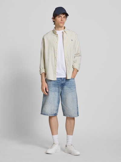 Männermodel trägt Jeansshorts im Used-Look mit Eingrifftaschen von REVIEW, Relaxed Fit, reine Baumwolle, blaue Farbtöne, Ganzkörperansicht von vorne.