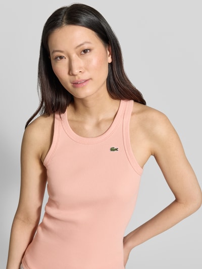 Frauenmodel trägt Slim Fit Tank Top aus reiner Baumwolle von Lacoste in Optik: Unifarben mit Logo-Stitching, Ripp, U-Ausschnitt, breite Träger, Nahaufnahme Oberkörper.