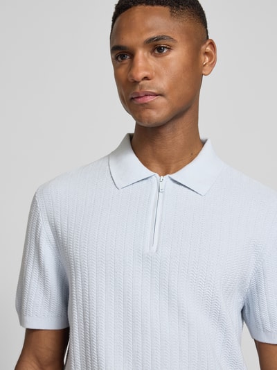 Männermodel trägt Poloshirt mit kurzem Reißverschluss und Polokragen von MCNEAL aus Reiner Bio-Baumwolle, Nahaufnahme Oberkörper.