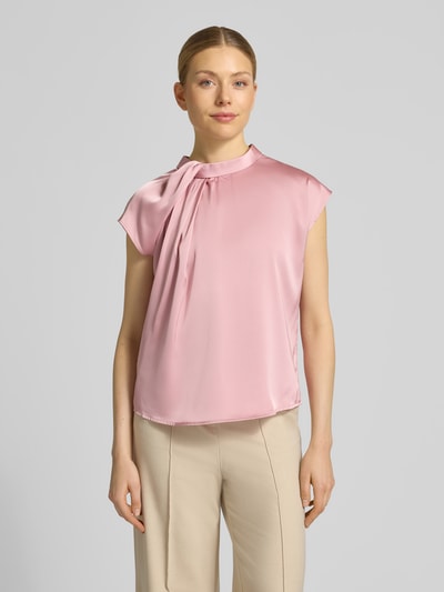 Vrouwenmodel draagt Blusenshirt uit satijn model 'Fleur' van Neo Noir in regular fit met drapering en ronde hals, ruglengte 58 cm maat 36, lichte roze kleur, gladde textuur, volledige lichaamsweergave van voren.