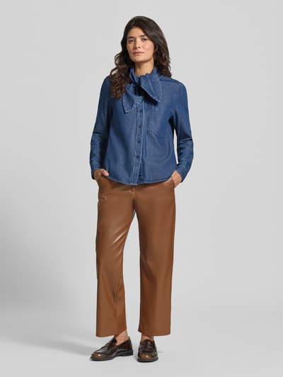Frauenmodel trägt Flared Fit Stoffhose in Leder-Optik von MORE & MORE in Braun, Eingrifftaschen, Knopfverschluss, Ganzkörperansicht von vorne.