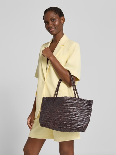 Frauenmodel trägt Shopper aus Ziegenleder in Flecht-Optik Modell 'Bamba' von MANGO, dunkles Braun, strukturierte Oberfläche, Nahaufnahme Oberkörper. Echtes Ziegenleder, offenes Hauptfach, Tragehenkel, Maße: 44x24x14 cm, Schulterriemen 58 cm.