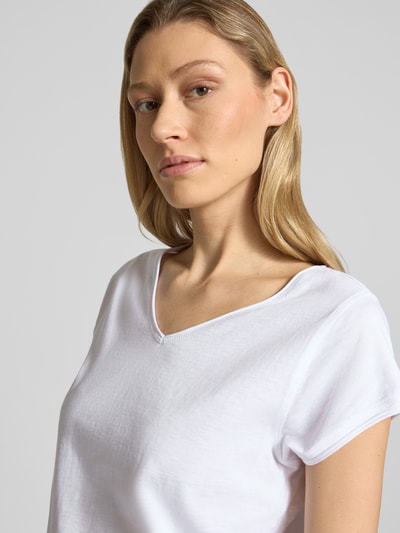 Vrouwenmodel draagt T-Shirt met V-hals van Christian Berg Woman in wit, pure katoen, regular fit, met rolzoom, detailopname bovenlichaam.