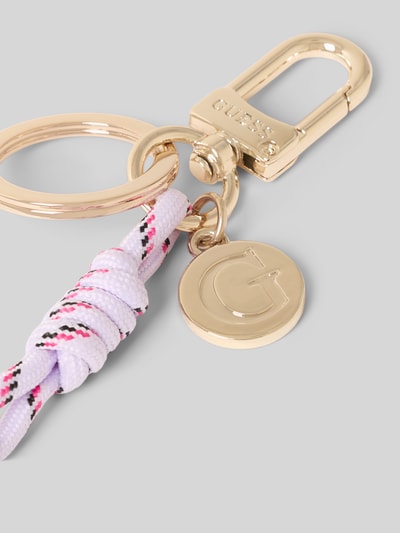 Produktfoto, Damen Schlüsselanhänger mit Logo-Detail von Guess aus goldfarbenem Metall mit Karabinerhaken, Schlüsselring und Motiv-Detail auf grauem Hintergrund