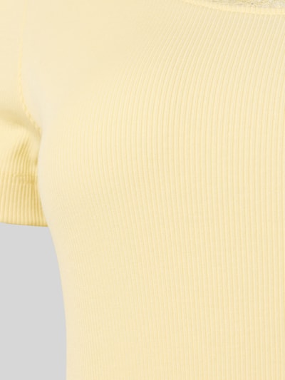 Frauenmodel trägt Pyjama-Oberteil mit Spitzenbesatz von Christian Berg Woman in zartem Gelb, Ripp-Optik, Baumwoll-Elasthan-Mix, Detailaufnahme.