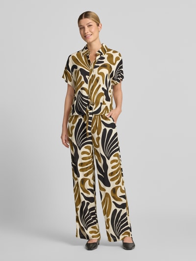 Frauenmodel trägt Regular Fit Bluse aus Viskose mit Knotendetail Modell 'FELDI' von Soyaconcept im Allover-Look, Ganzkörperansicht von vorne.