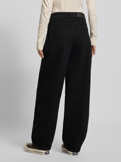 Frauenmodel trägt Tapered Fit Jeans mit 5-Pocket-Design Modell 'HAZAL' von Noisy May, reine Baumwolle, lockerer Schnitt, Ganzkörperansicht Rückansicht.