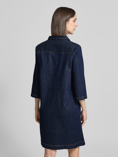 Vrouwenmodel draagt Regular Fit Jeanskleid aus Baumwoll-Mix van Tom Tailor in donkerblauwe denimlook met motiefstitching, knoopsluiting, borstzakken en steekzakken, 3/4-mouw, knielange lengte, labelpatch, mix van katoenmix, geheellichaamsaanzicht rugaanzicht.