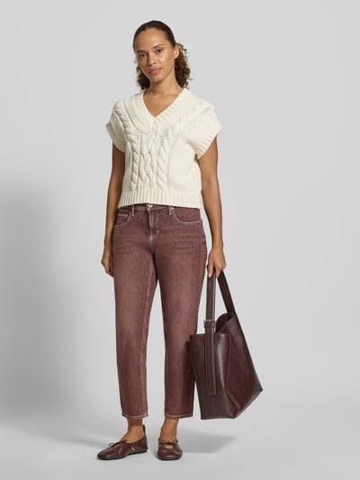 Frauenmodel trägt Tapered Fit Jeans aus Baumwoll-Mix Modell 'MILEY' von Brax in leicht verwaschenem Braunrot, 5-Pocket, Twill-Textur, fixierter Umschlag, Ganzkörperansicht von vorne.